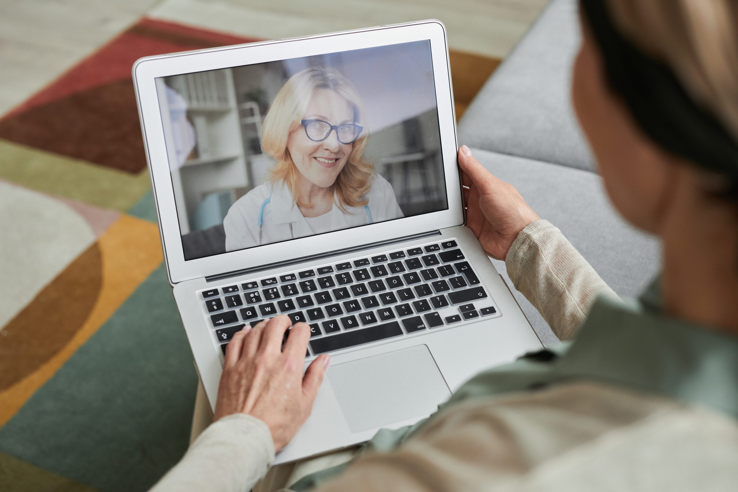 Consultation en ligne avec un médecin, patient utilisant un ordinateur portable pour recevoir des conseils médicaux à distance, ambiance rassurante et moderne.