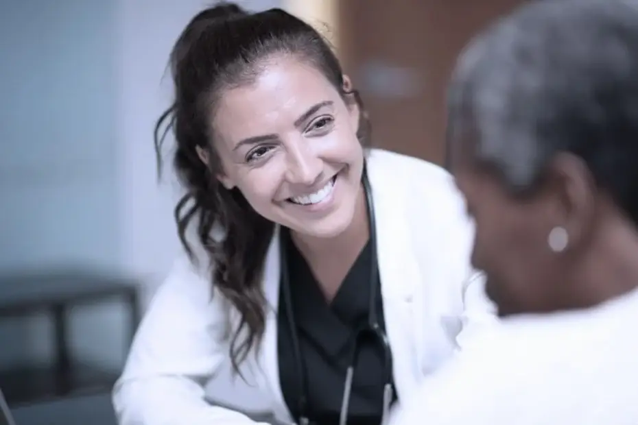 Médecin souriante en consultation avec un patient, illustrant les services de santé accessibles de la Clinique Omicron.