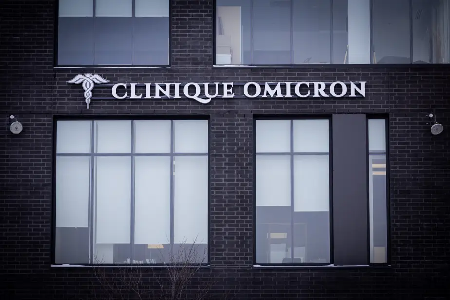 Clinique Omicron, enseigne moderne sur bâtiment, vitres claires, engagement envers la transparence et qualité des soins.