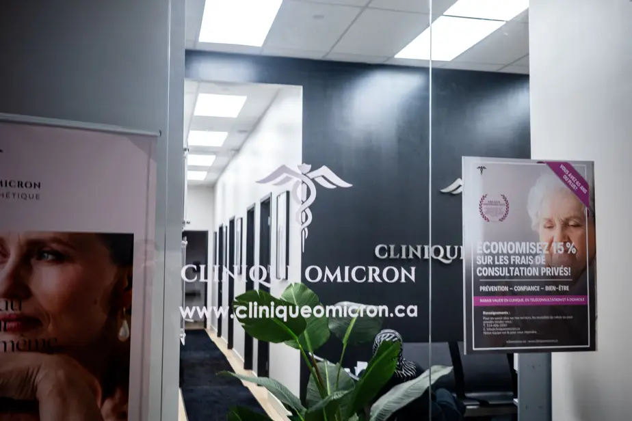Exterior façade of Clinique Omicron with sign and illuminated windows
